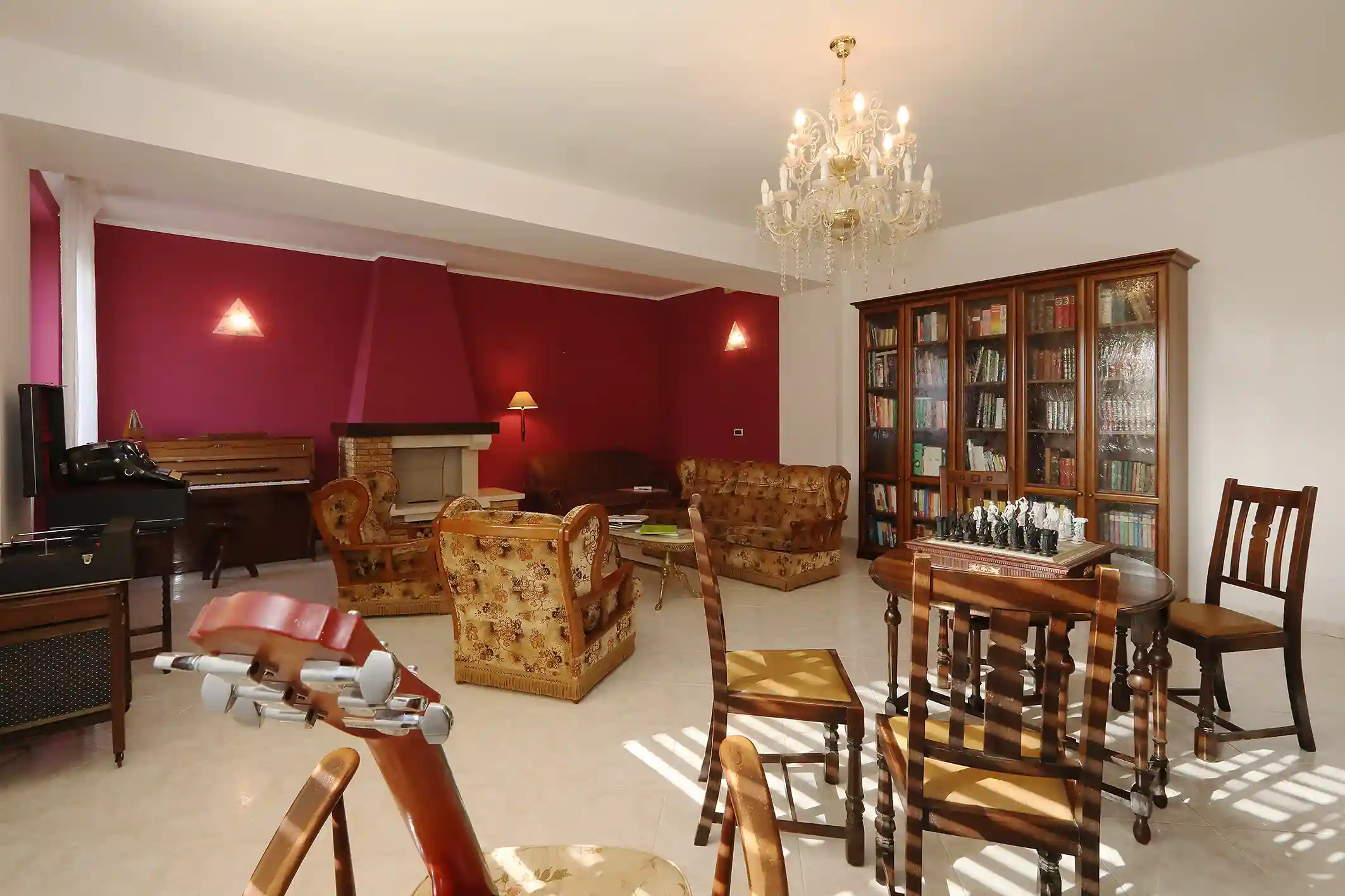 Sitting room with fireplace, piano and library at the La Vita Sukha villa