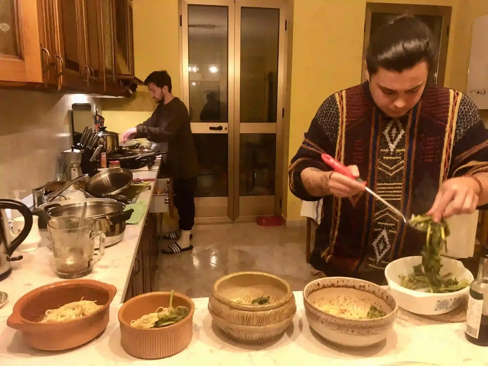Guests cooking together during a seasonal coliving month at La Vita Sukha in Puglia